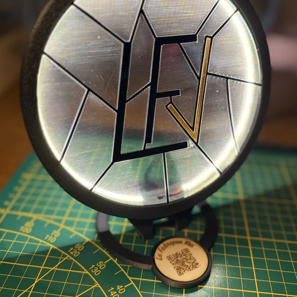 Le Socle Vitrail LED allumé, avec une pastille ronde gravée au nom de La Fabrique Vié et un QR code, clipsée en dessous.