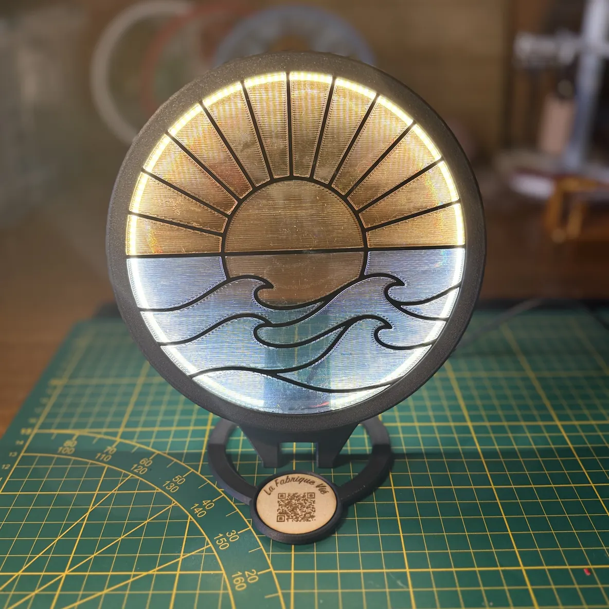 Le filtre Solaire — soleil levant au-dessus des vagues — monté sur le Socle Vitrail LED et allumé.