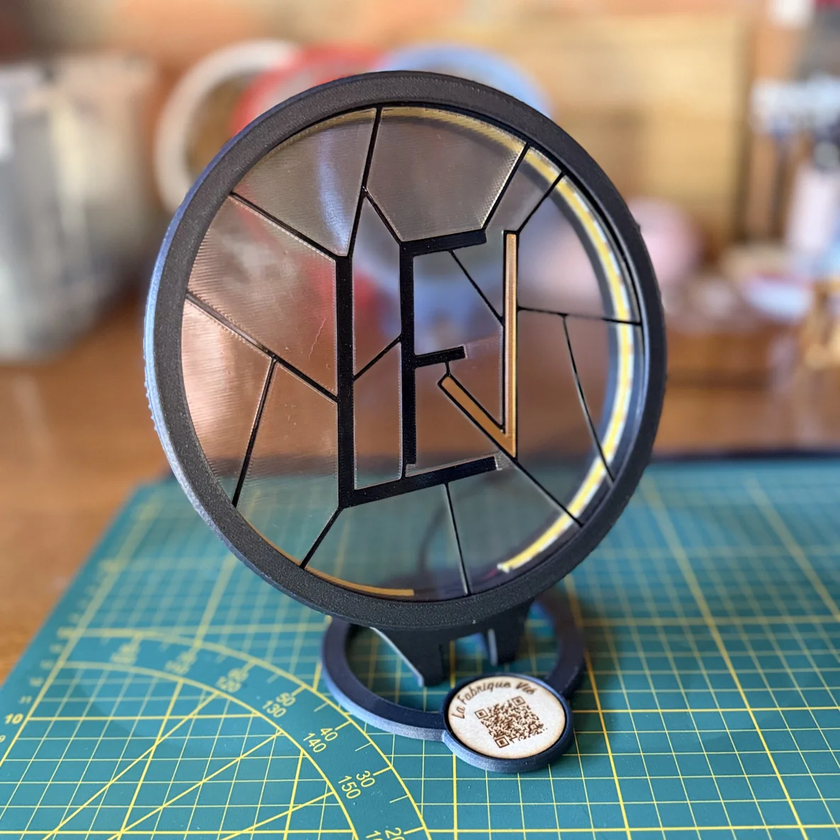 Le même coffret éteint : le monogramme LFV en vitrail translucide sur son socle, sans éclairage.